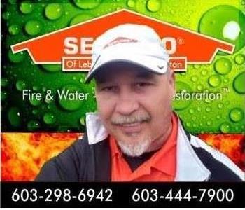 image of man in white hat with servpro background