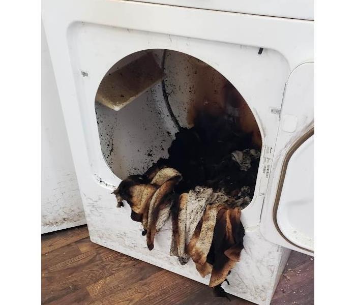 Picture of dryer with burnt clothes inside